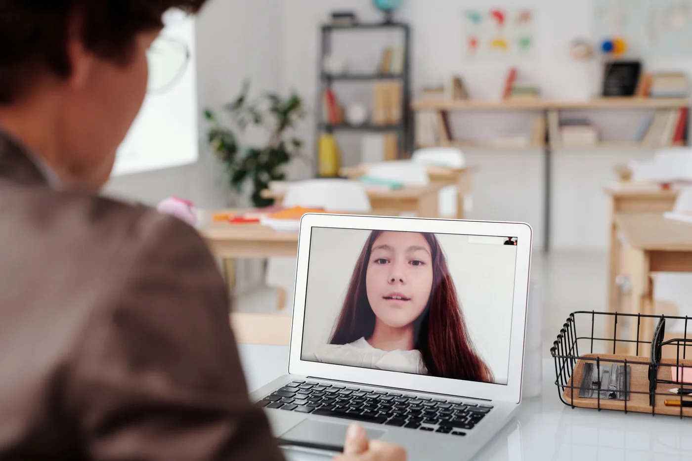 Teacher conducting a remote lesson with a student on a laptop