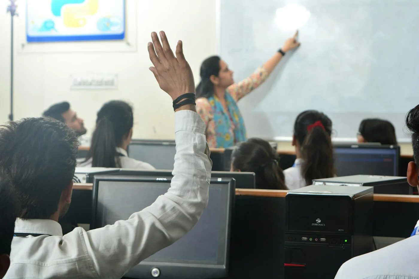 Teacher leading a classroom discussion with students and technology